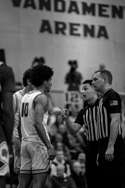 Basketball player speaking with a referee in black and white