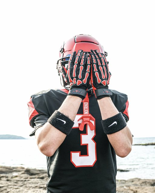 Football player number three posing with gloved hands over his face