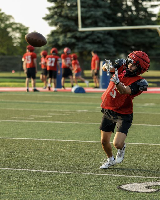 Football receiver catching a pass during practice