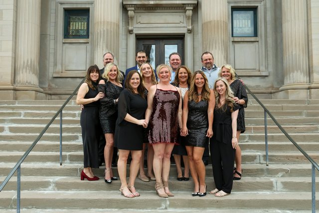 Group dressed for a formal event on building steps