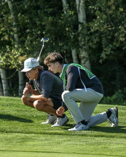 Two golfers lining up a putt