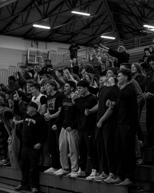 Fans cheering in the gym in black and white