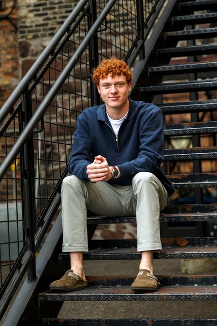 Portrait seated on outdoor metal stairs